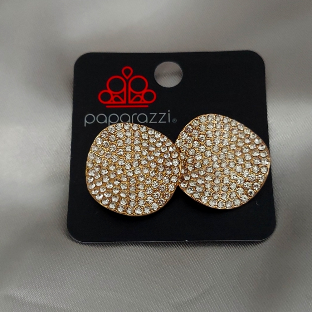 Clip-on rhinestones and gold earrings.